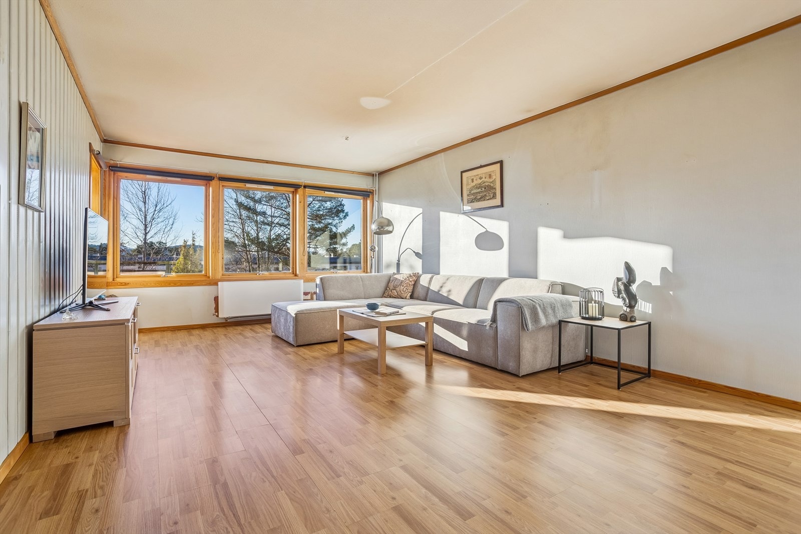 Den romslige stuen har laminatgulv og store vindusflater som slipper inn rikelig med dagslys. Galleribilde