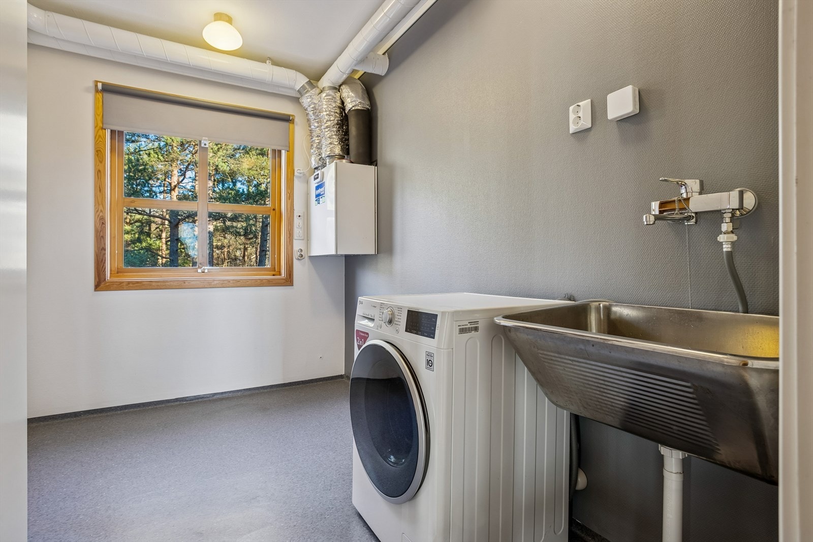 Eget vaskerom med skyllekum i stål, opplegg for vaskemaskin, og balansert ventilasjonsaggregat fra 2014. Galleribilde