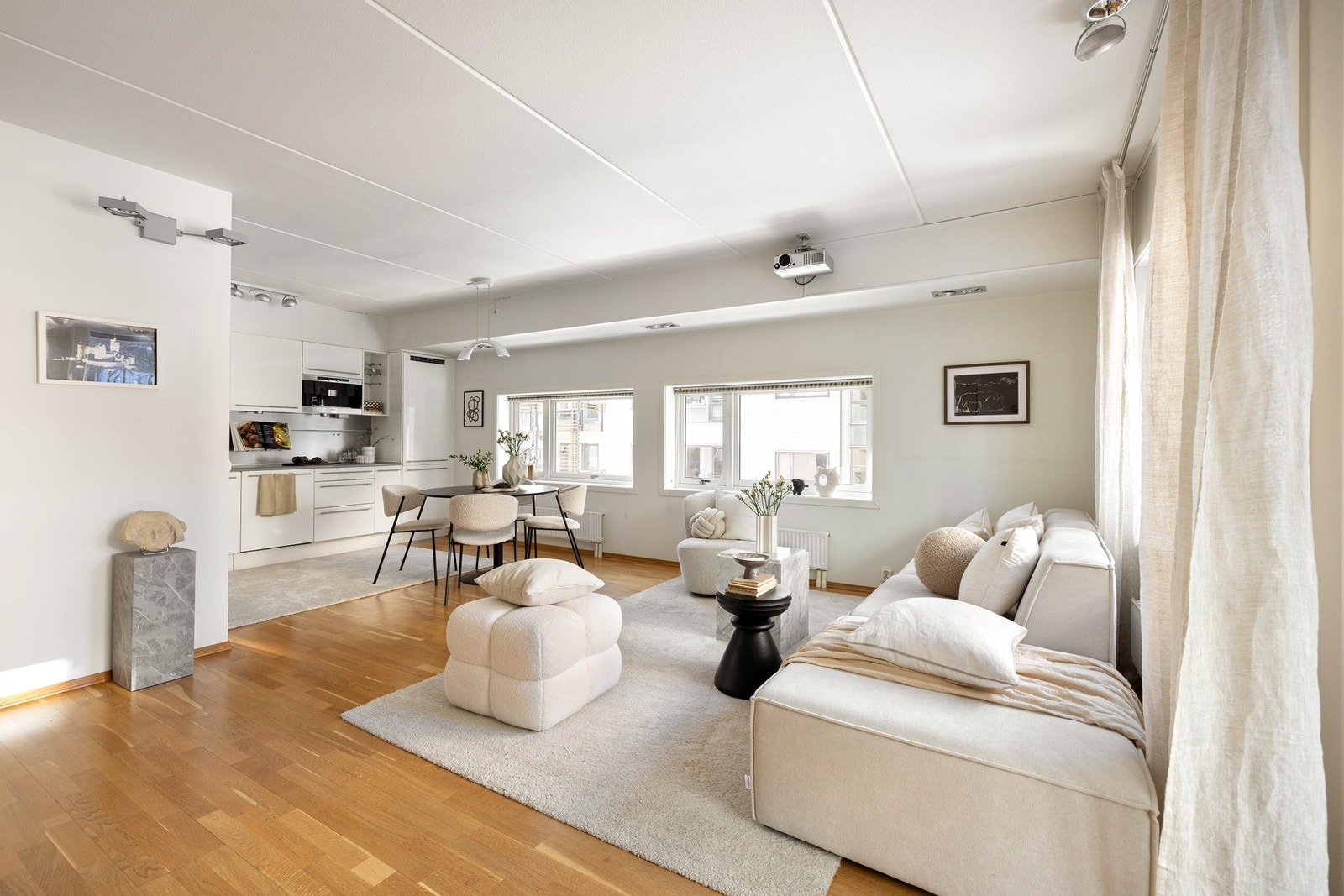 Her får du en åpen stue/kjøkken løsning der kjøkkenet ligger godt tilbaketrukket i egen del. Galleribilde