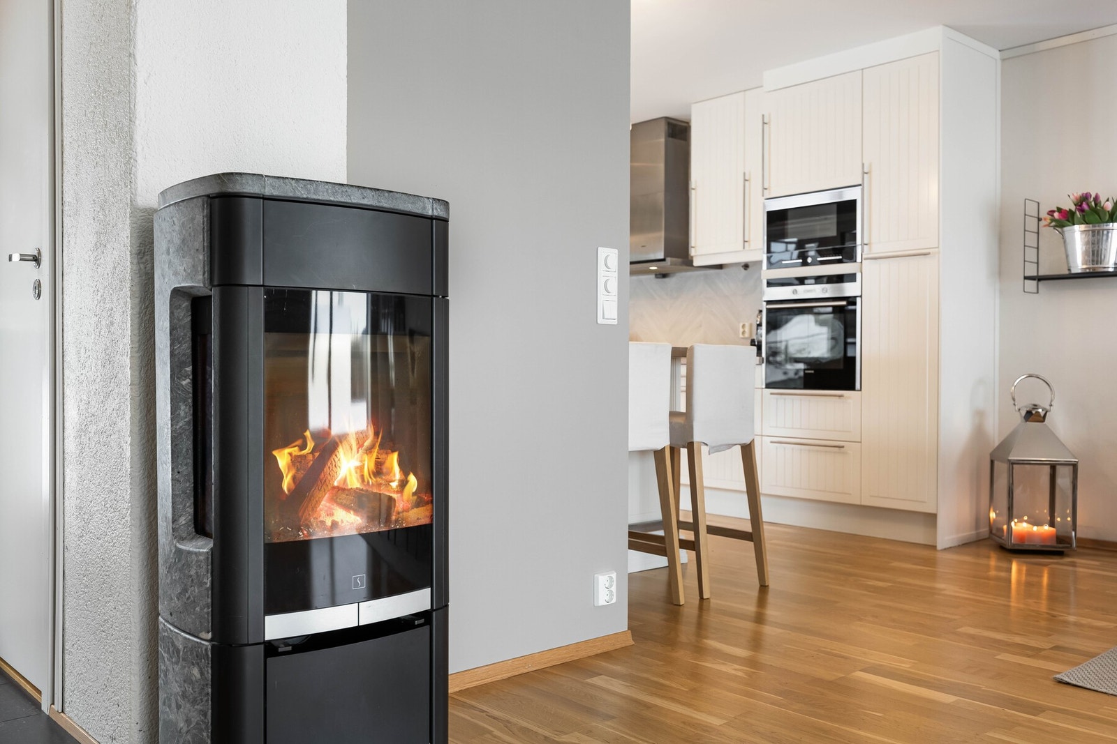 Strategisk plassert ildsted, som gir varme til både kjøkkenet og stuen Galleribilde
