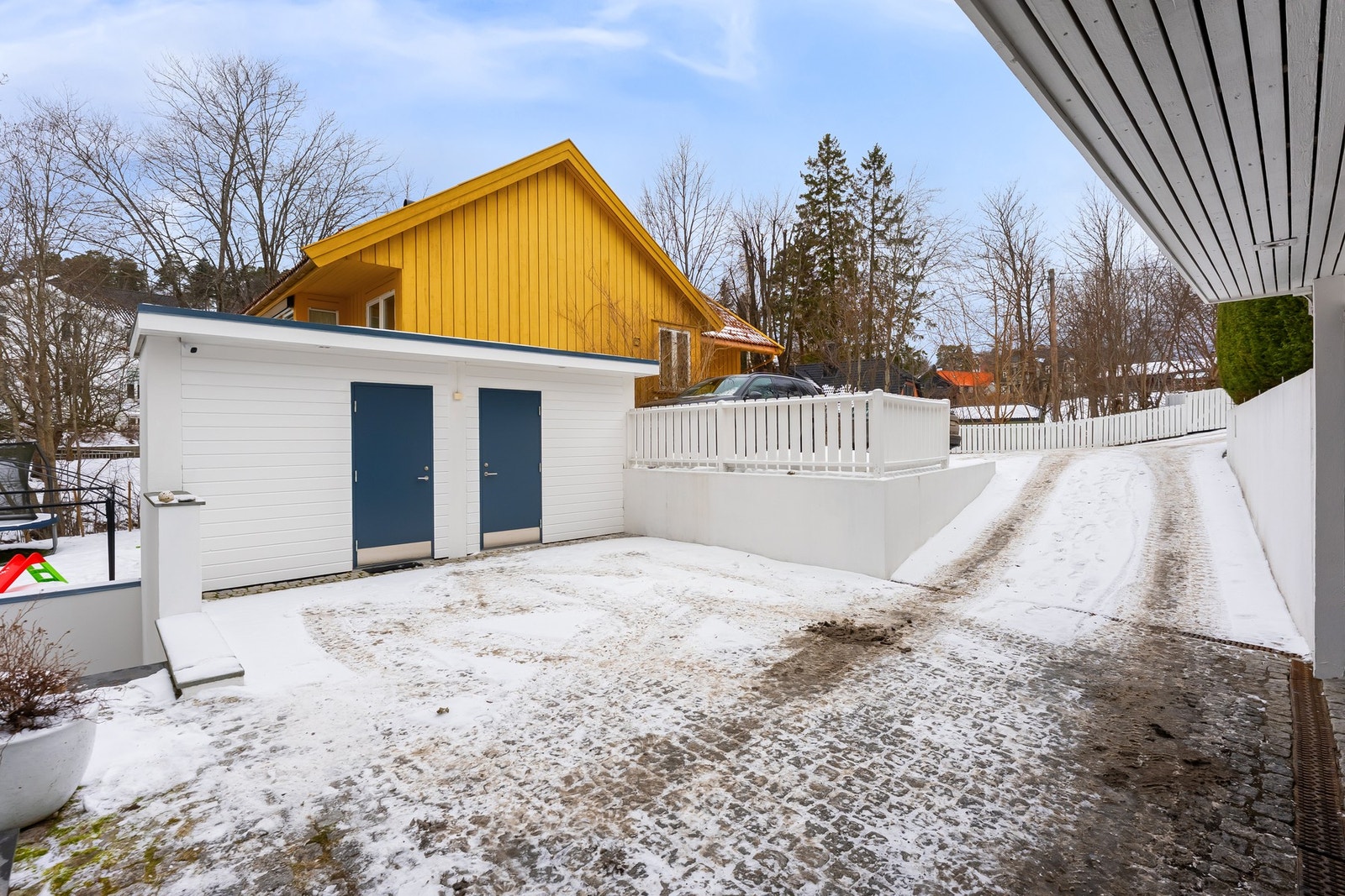 Romslig gårdsplass med to praktiske redskapsboder. Galleribilde