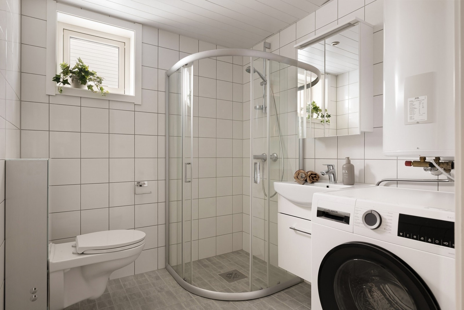 Pent flislagt bad med opplegg for vaskemaskin Galleribilde