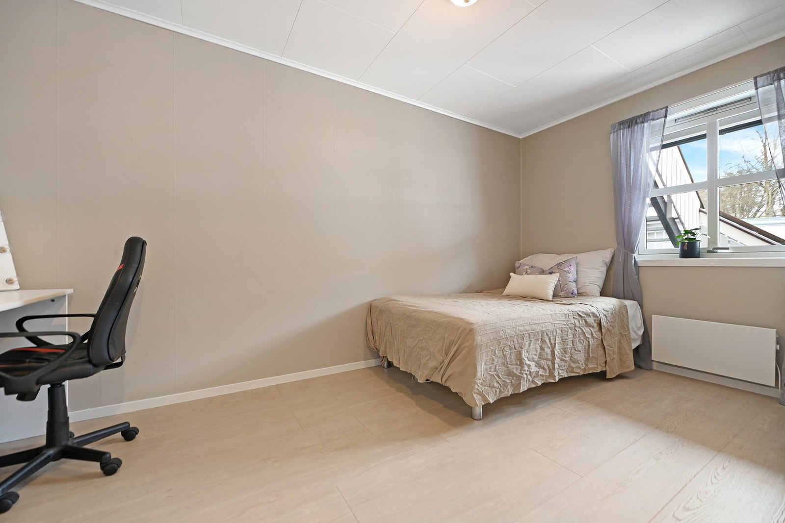 Rommet har lyst gulv, beige vegger og et vindu som gir naturlig lysinnslipp. Galleribilde