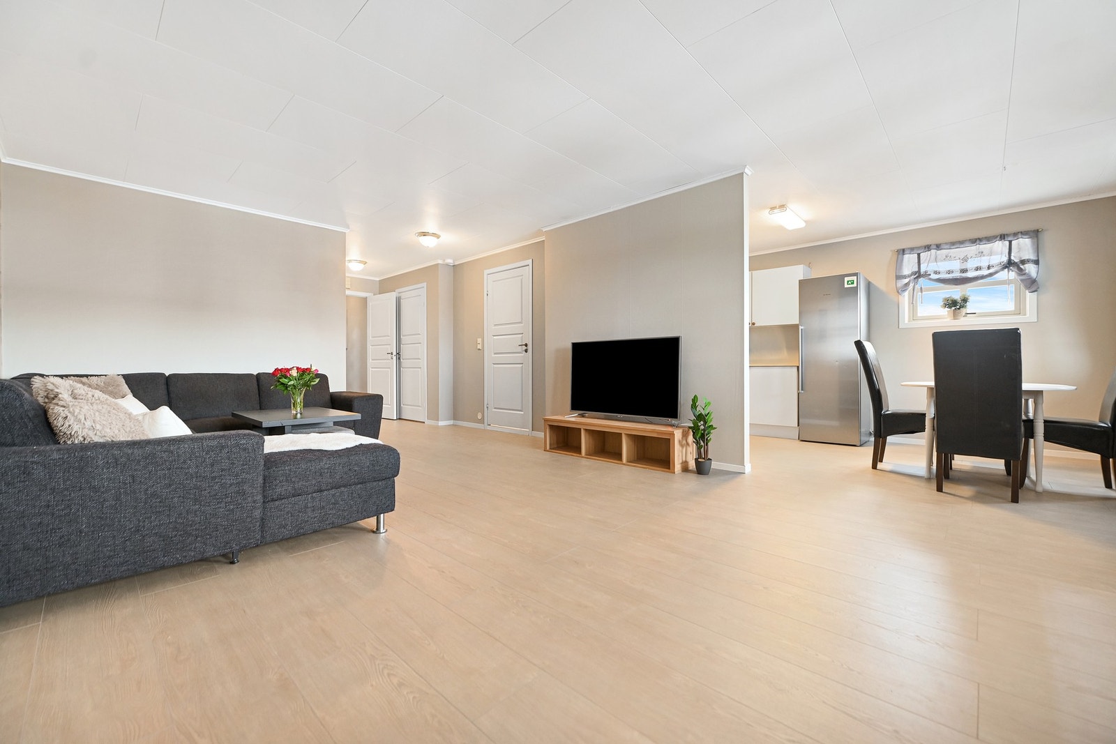 Lys stue med god romfølelse, åpen løsning mot kjøkken og spiseplass. Store vinduer gir rikelig med naturlig lys. Galleribilde