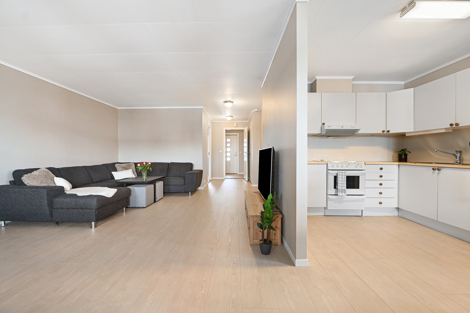 Stuen har god romfølelse med lyse flater og naturlig lys, og er åpen mot kjøkkenet for en sosial atmosfære. Galleribilde