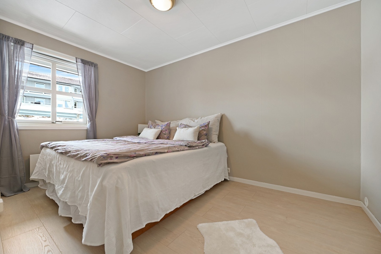 Soverommet har lysmalte vegger og gulv, med stor vindu som gir godt med naturlig lys. Galleribilde