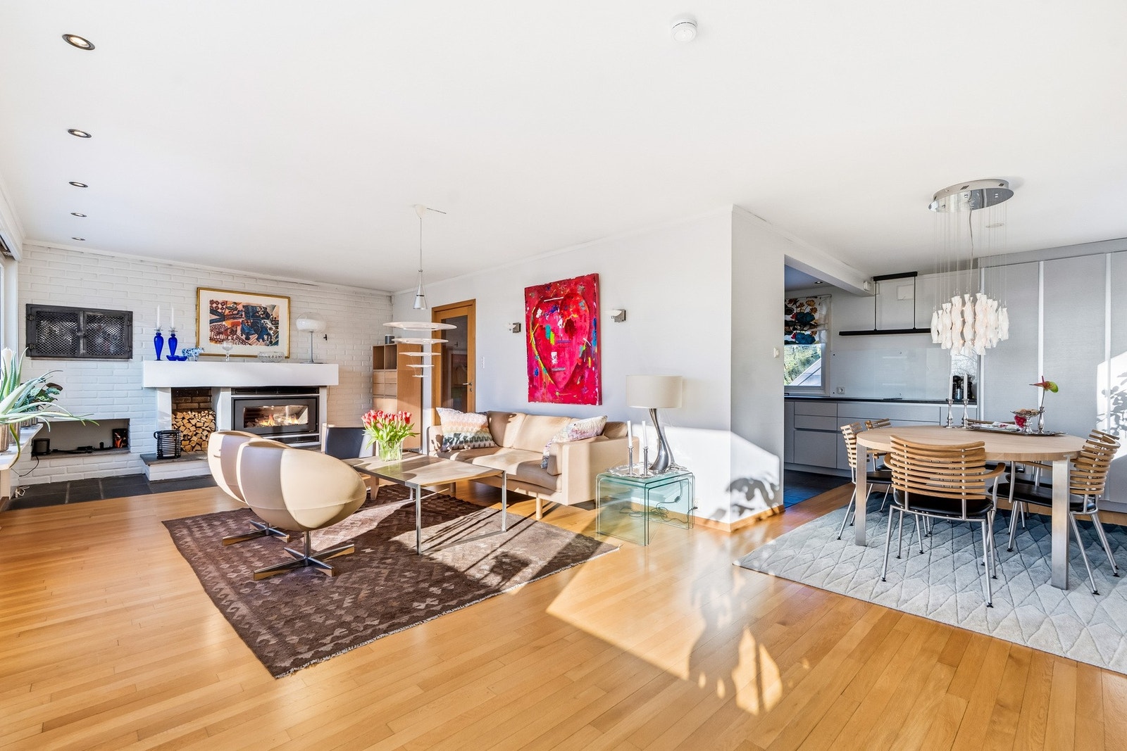 En lys og flott vinkelstue med moderne peisovn og utgang til balkong. Galleribilde