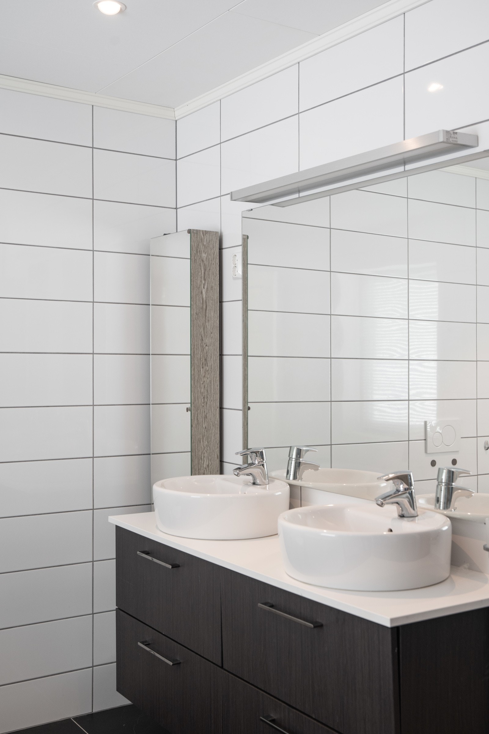 Baderom II inneholder veggmontert toalett, badekar, dusj og innredning med dobbel servant. Galleribilde