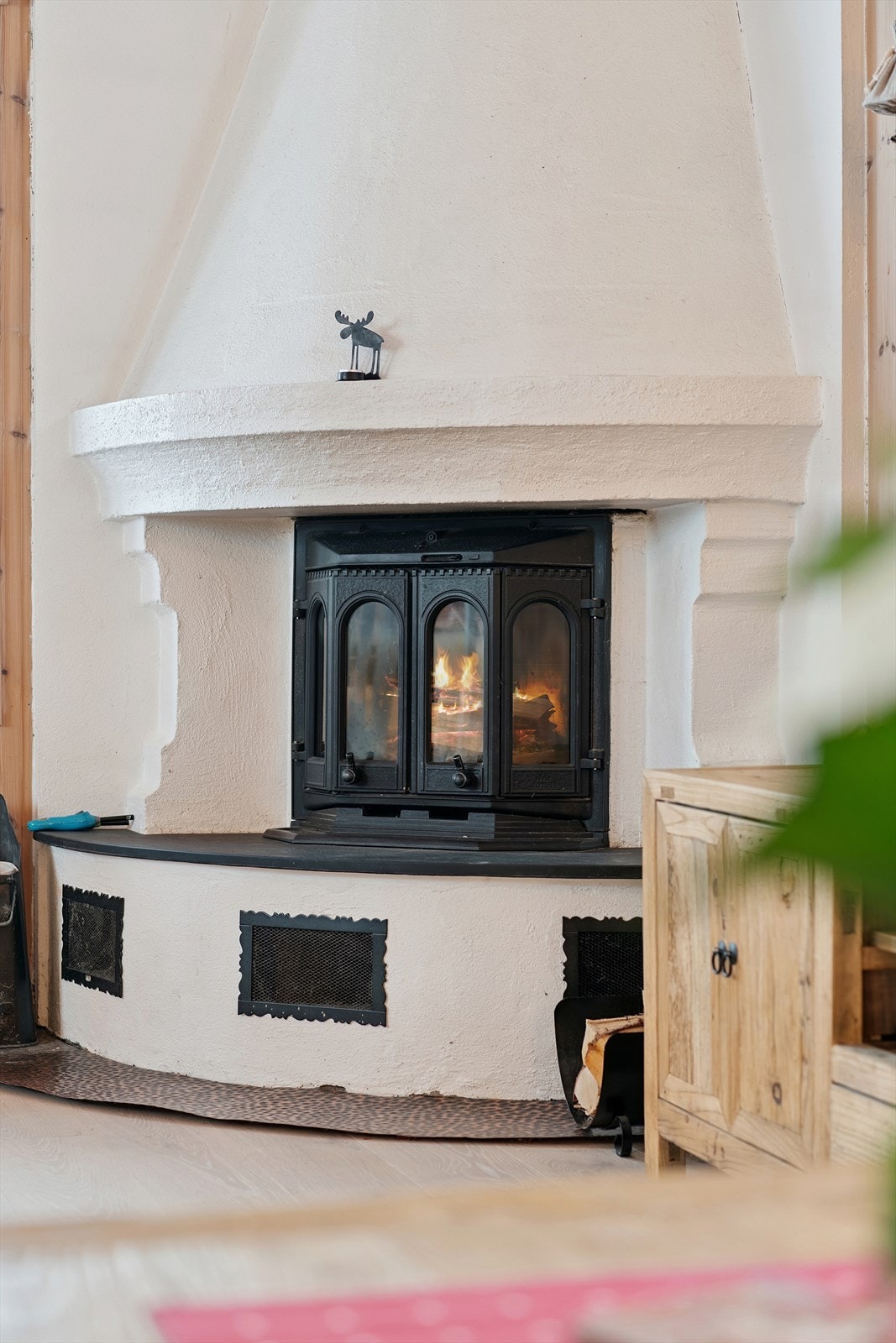 En sentralt plassert elementpeis med peisinnsats skaper en lun atmosfære i stuen. Galleribilde