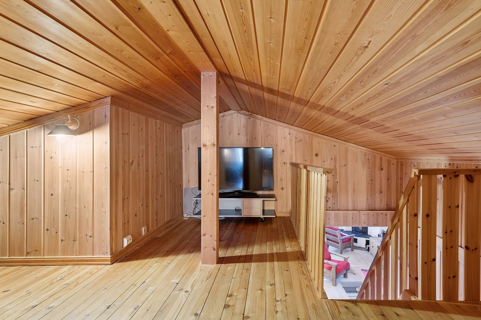 Fra hemsen er det utsyn mot stuen. En bratt tretrapp med rekkverk forbinder etasjene. Galleribilde