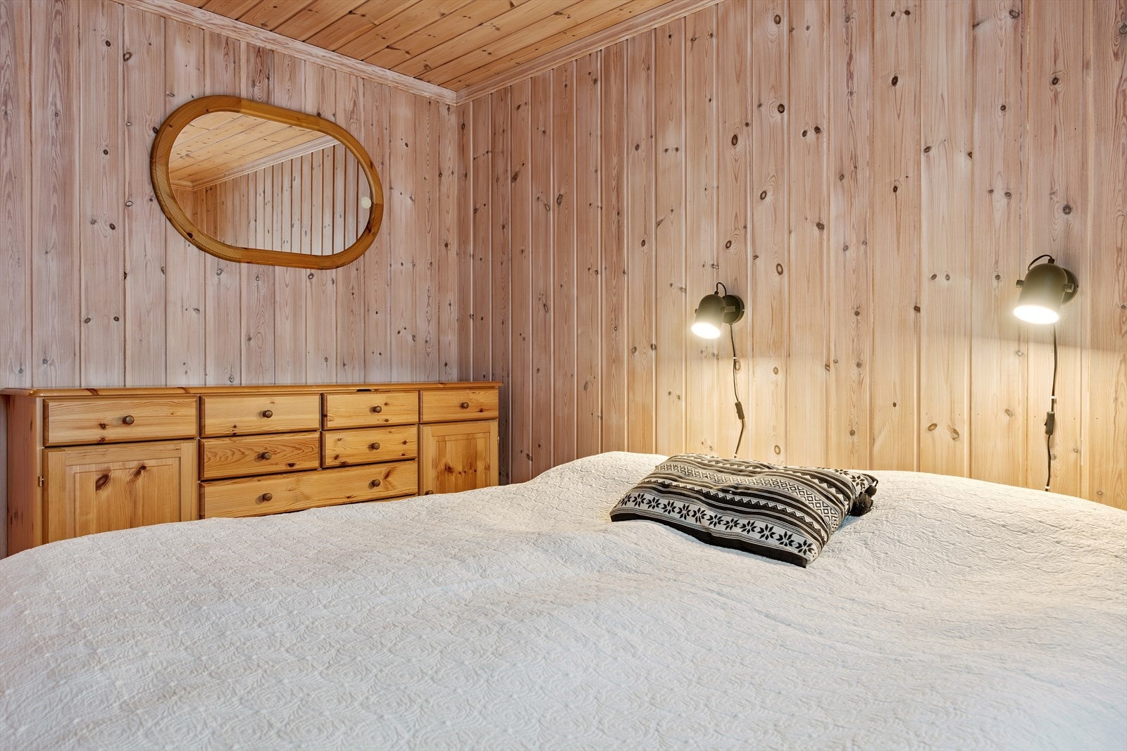 Et av soverommene i første etasje har god plass til dobbeltseng og oppbevaring. Galleribilde