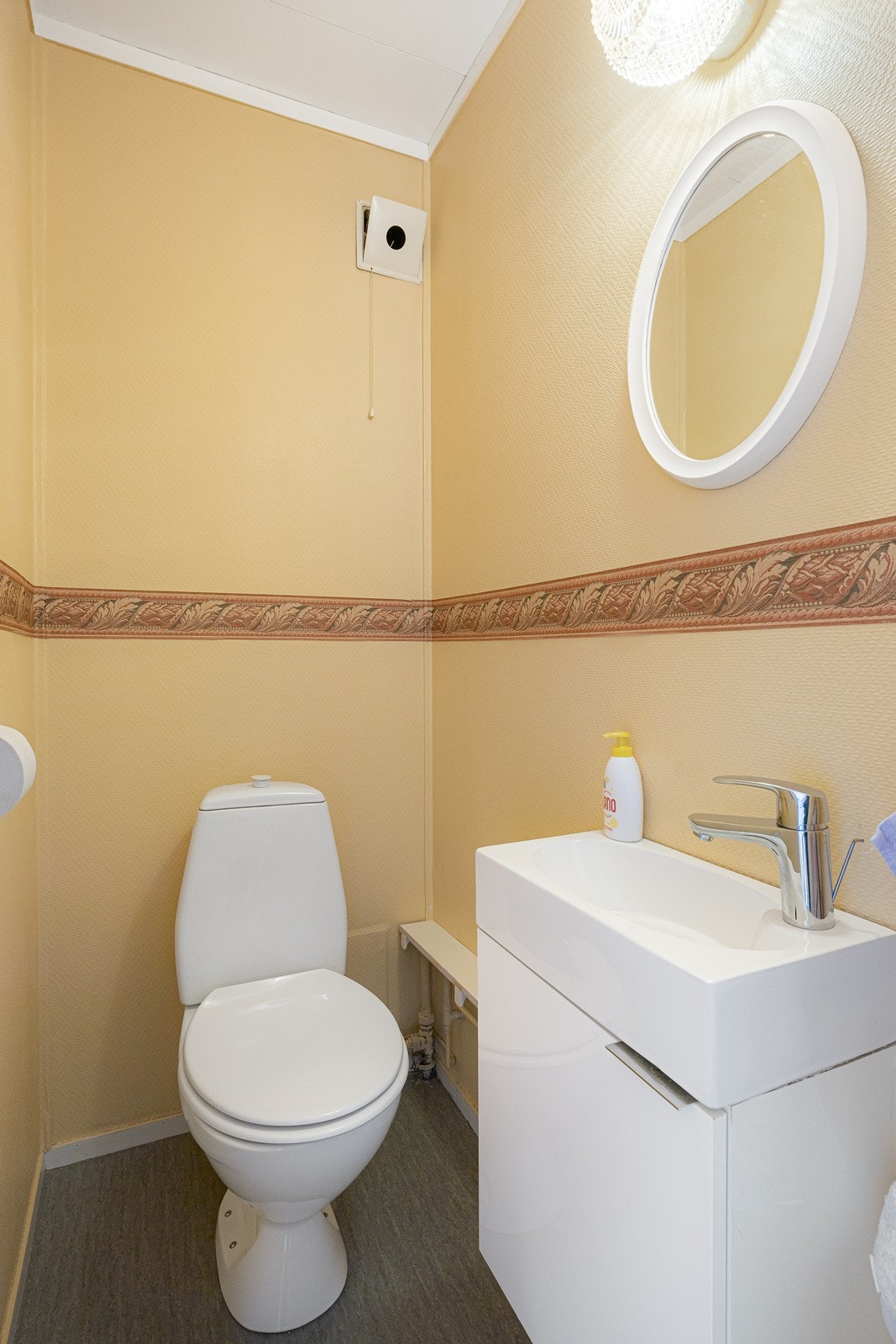 På wc-rommet er et servant, speil, toalett og belysning. Galleribilde