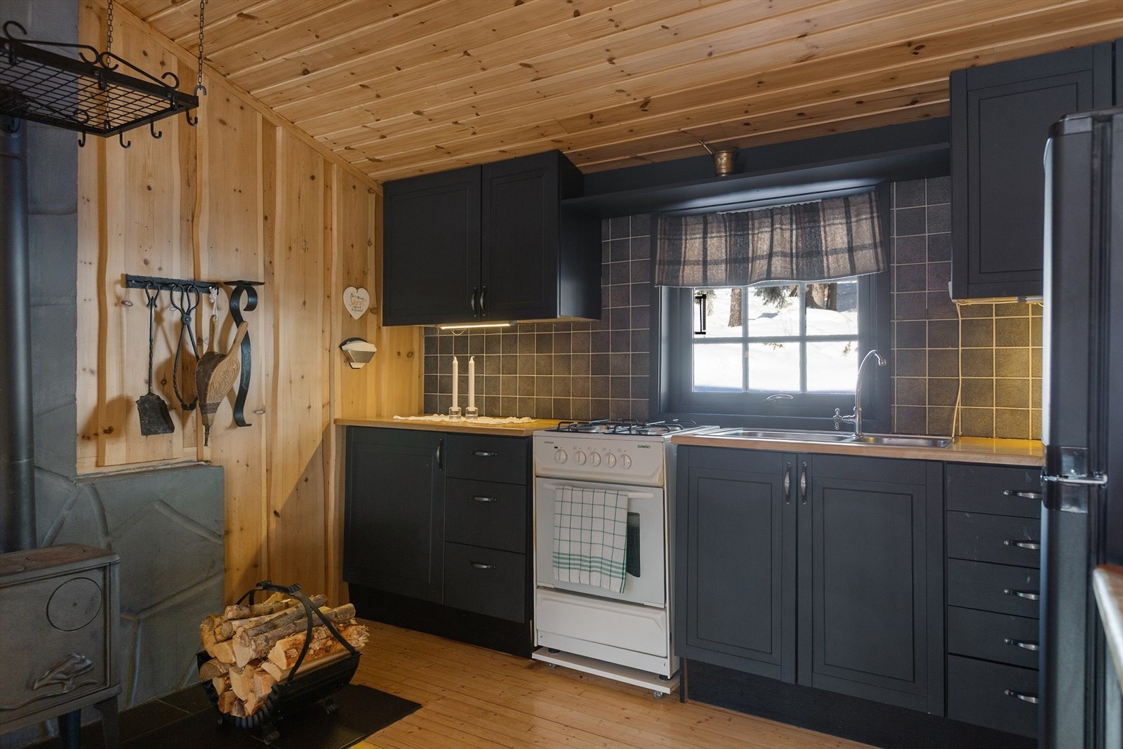 Kjøkkenet har en pen og funksjonell innredning med profilerte, malte fronter og laminert benkeplate. Galleribilde