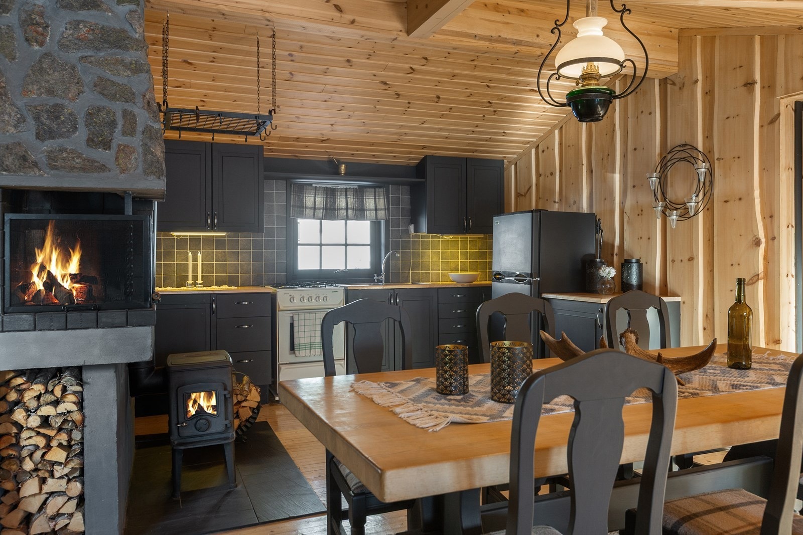 En stilig peis med natursteinsforblendet hette er sentralt plassert, slik at synet av flammene kan nytes i hele rommet. Galleribilde