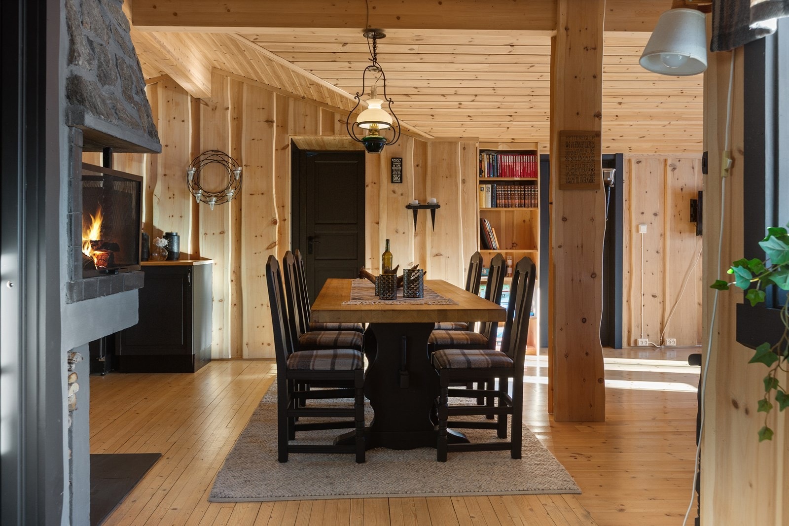 Oppholdsrommene har en lys og åpen løsning mellom stue, kjøkken og spiseplass. Her er det spennende takvinkler og flott villmarkspanel på veggene. Galleribilde