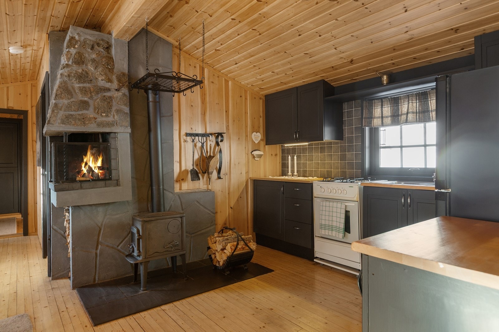 Nær kjøkkenet er det også vedovn med innsyn - perfekt for å skape varme og stemning på kalde dager. Galleribilde