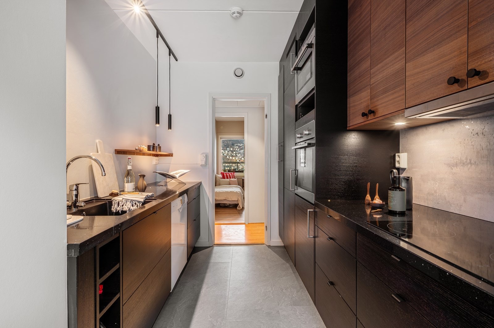 Stilrent uttrykk med finérte fronter og benkeplate i stein. Galleribilde