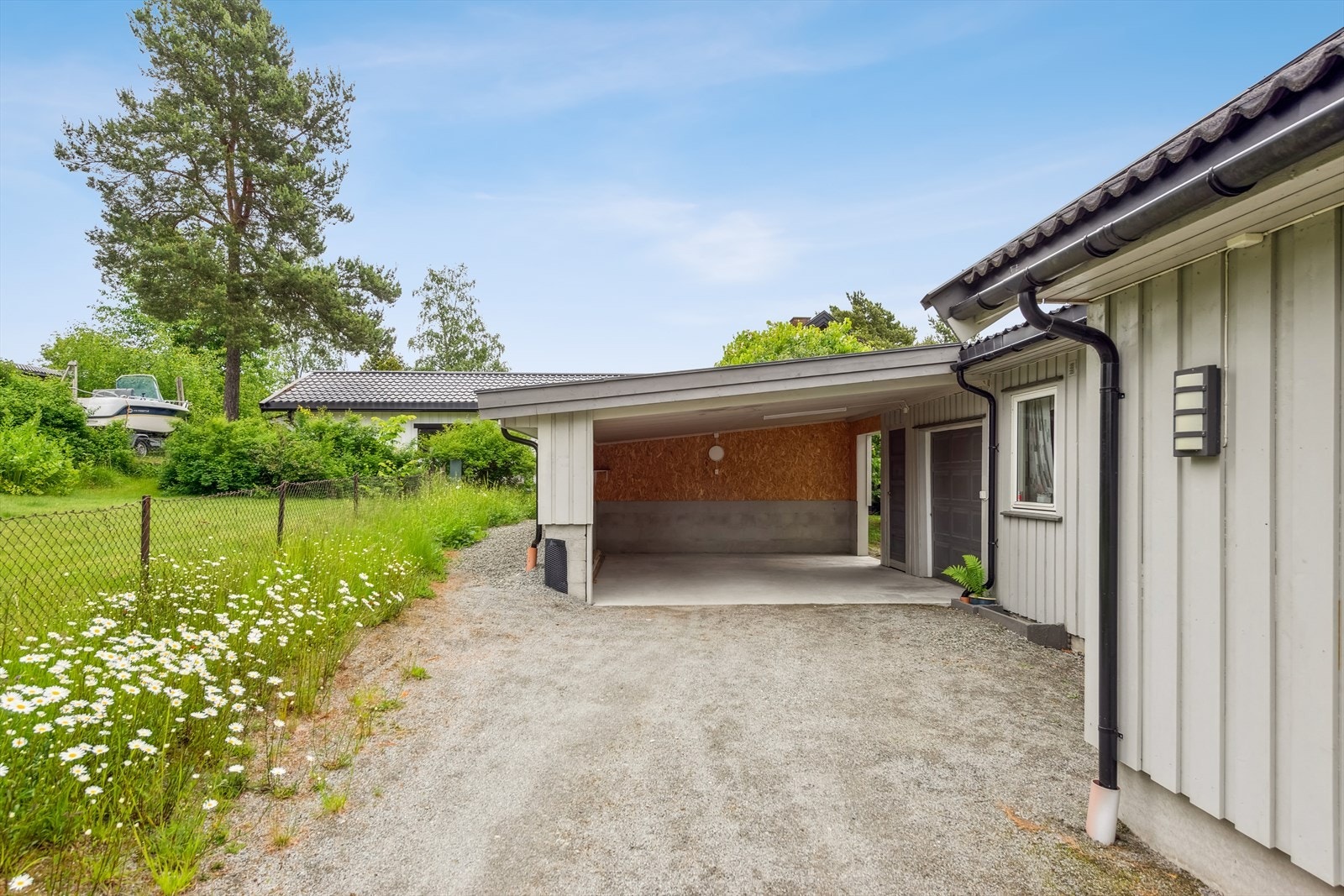 Den inntilbygde carporten fra 2022 gir skjermet parkering for én bil. Galleribilde