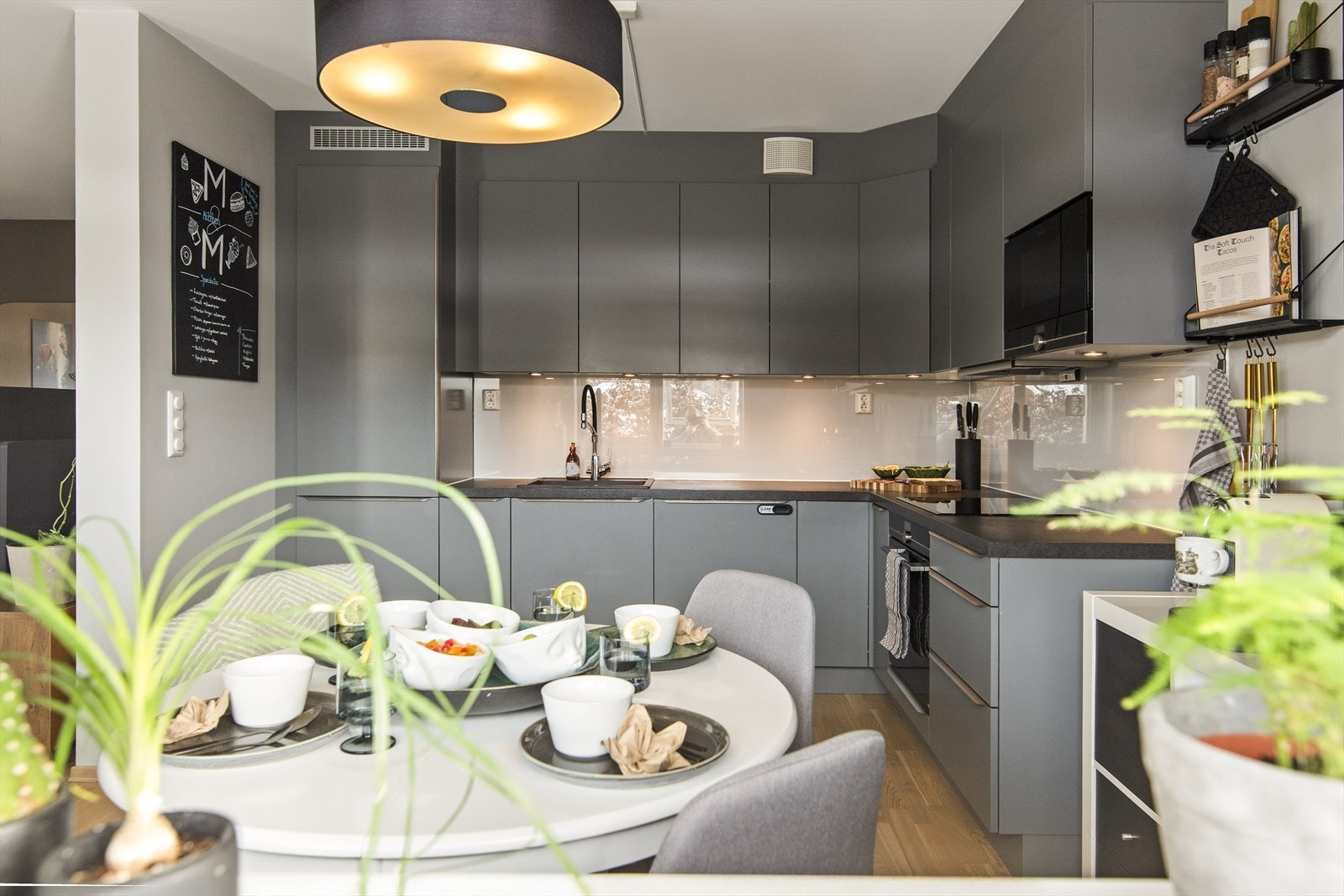 Integrerte hvitevarer som stekeovn, kokeplate, ventilator, kjøleskap med frys og oppvaskmaskin gir et helhetlig og moderne uttrykk. Galleribilde