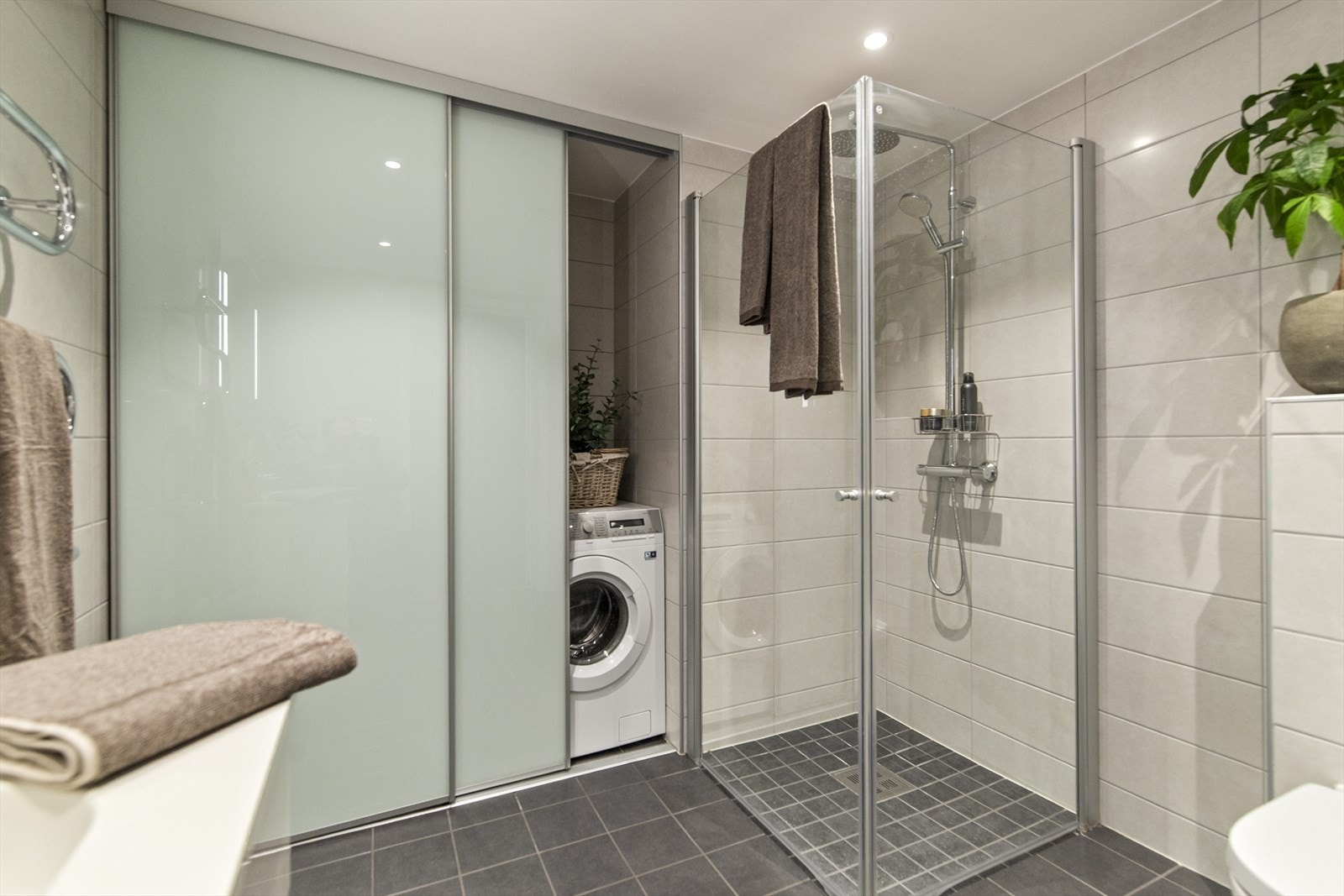 Det er opplegg til vaskemaskin innenfor skyvedører på badet. Merk at vaskemaskinen som står der i dag er en mindre modell for at skapdørene skal kunne lukkes. Galleribilde