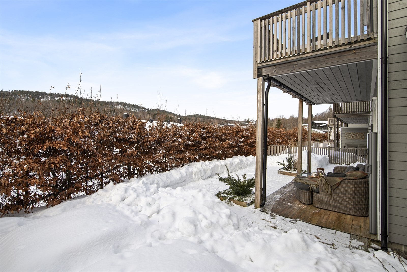 Uteområdet er pent opparbeidet med steinsatte kanter, blomsterbed og beplantning - et hyggelig og lettstelt sted å nyte solen. Galleribilde