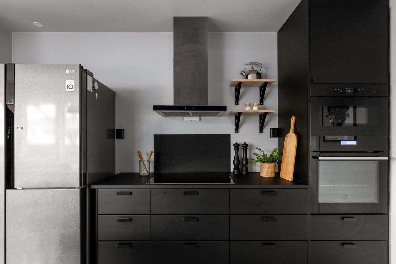 Kjøkkenet har sorte fronter og stilrent design. Galleribilde