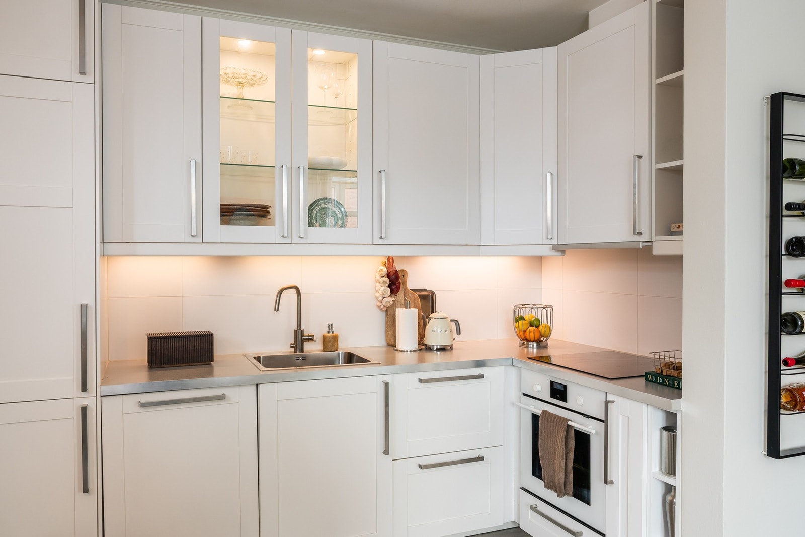 Integrert kjøleskap med fryser i nedre del, oppvaskmaskin, komfyr, platetopp og mekanisk avtrekk. Galleribilde