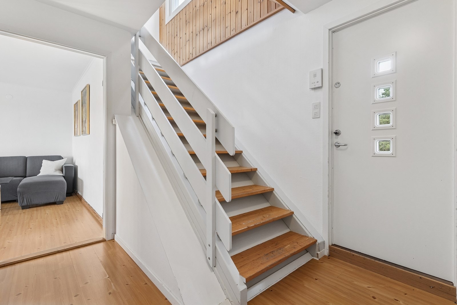 Rommet har trappeløp videre opp til boligens øvre plan, og plass til oppheng av yttertøy og skosone. Galleribilde