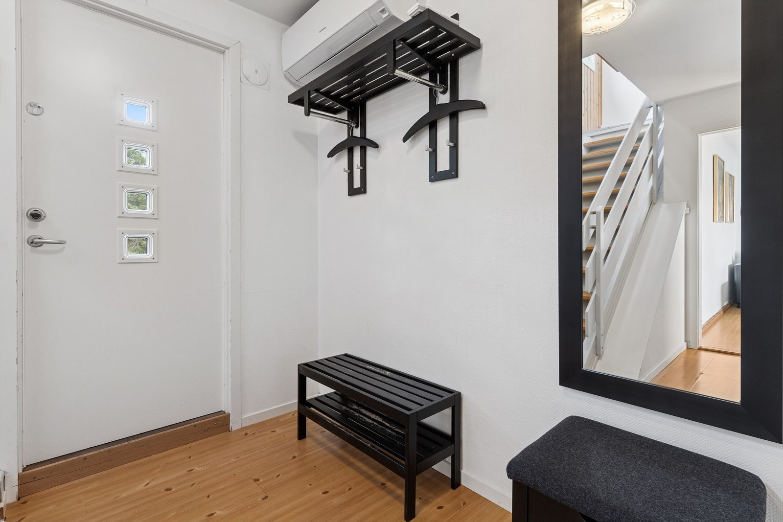 Velkommen inn i en lys og åpen entré med parkettgulv og malte vegger som gir et ryddig og innbydende førsteinntrykk. Galleribilde