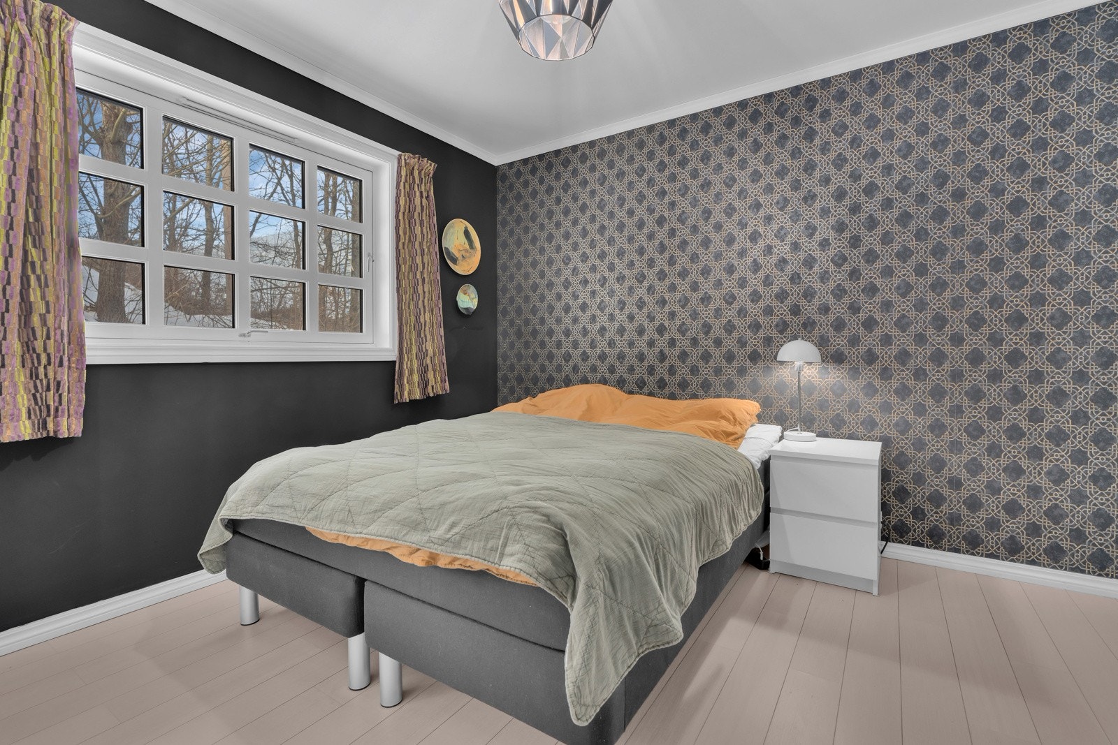 Romslig soverom I som er malt i en delikat farge og har tapet på den ene veggen. Galleribilde