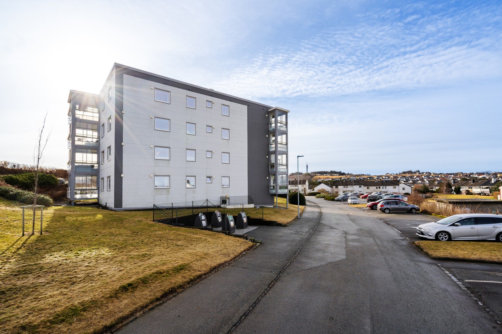 Parkering på felles parkeringsplass med mulighet for el-bil lader. Galleribilde