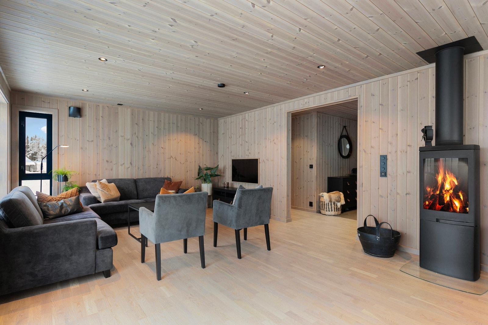 Midt i rommet er det en flott peisovn med glassdør som gir god varme og hygge. Galleribilde