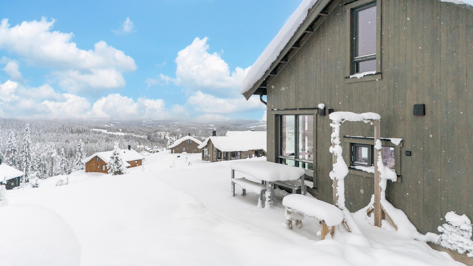 Fritidsboligen er plassert på en høyde i terrenget med utsikt over landskapet. Galleribilde