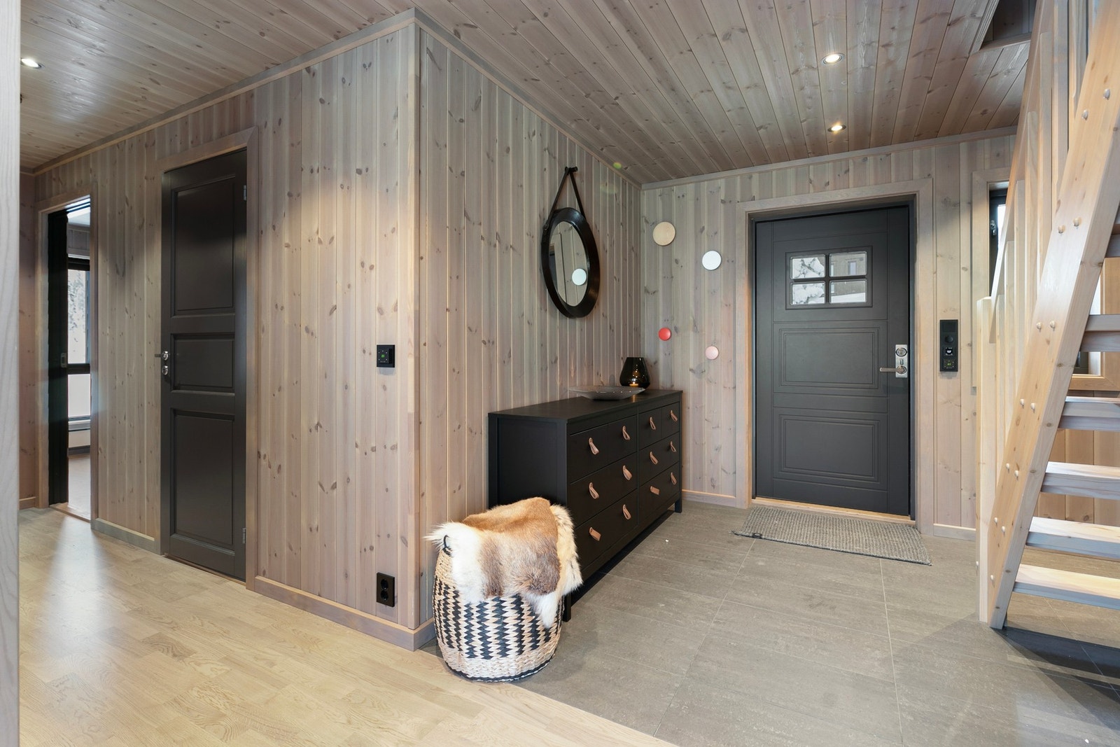 En romslig entre med fliser på gulv og panel på vegger gir et godt førsteinntrykk av fritidsboligen Galleribilde