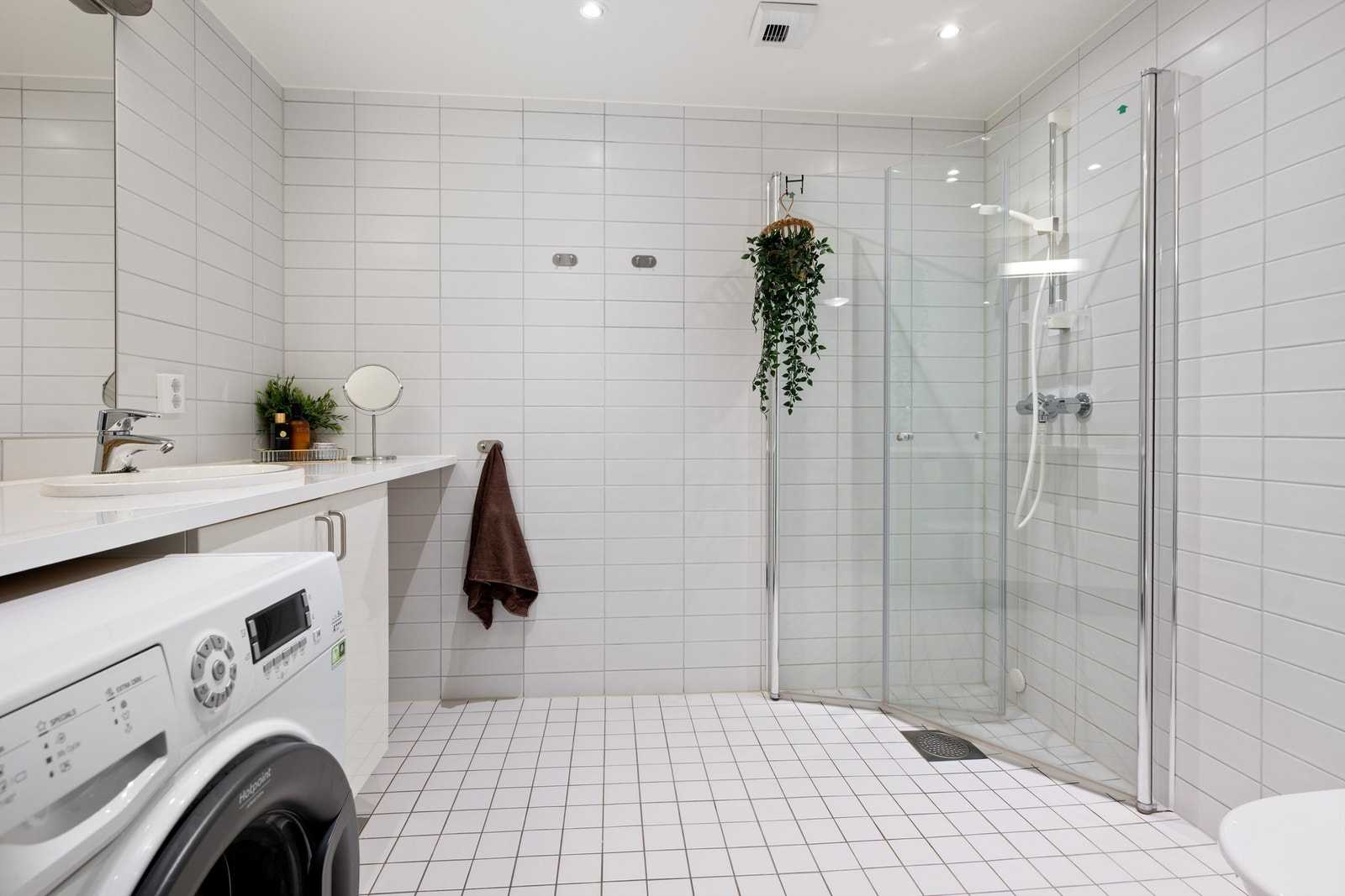 Badet har flislagt gulv med gulvvarme og flislagte vegger. Himlingsflate utført i malt glatt flate med downlights Galleribilde