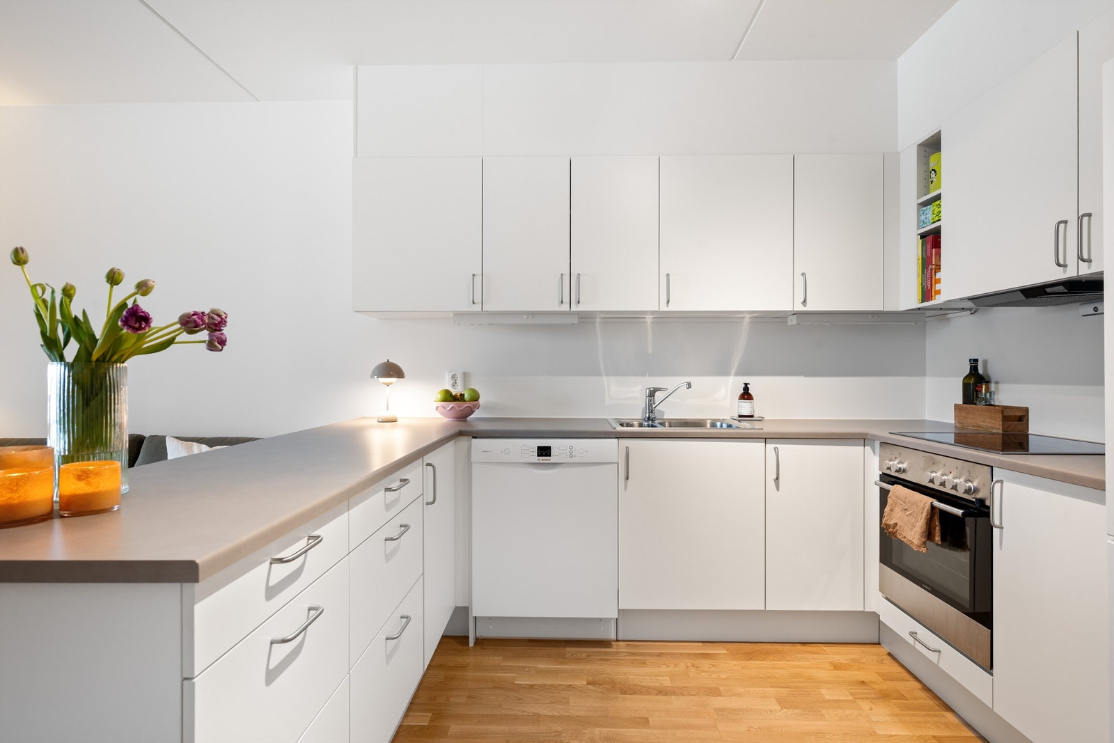 Kjøkkenet har god benk- og skapplass og integrert komfyr og keramisk platetopp. Galleribilde