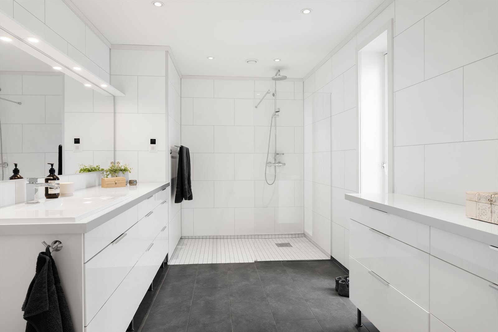 Flott baderom med flislagt gulv med mosaikk i dusjsone. Galleribilde