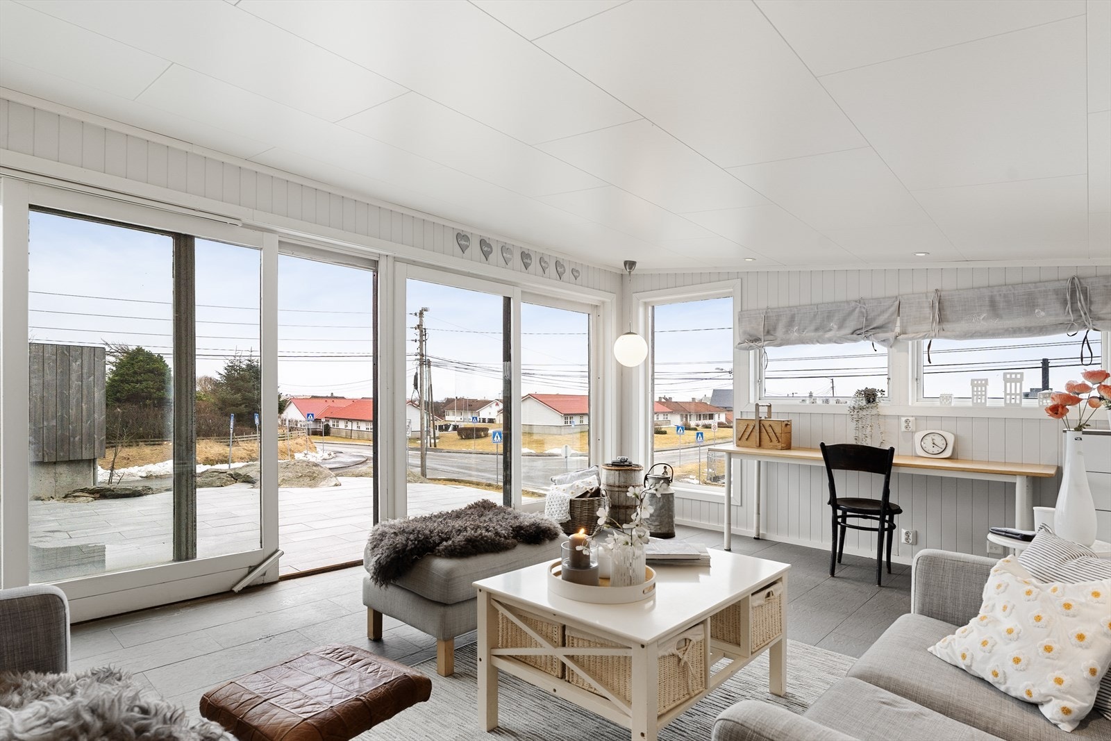 Lun og innbydende hagestue med malt panel på veggene og lyse himlingsplater. Galleribilde