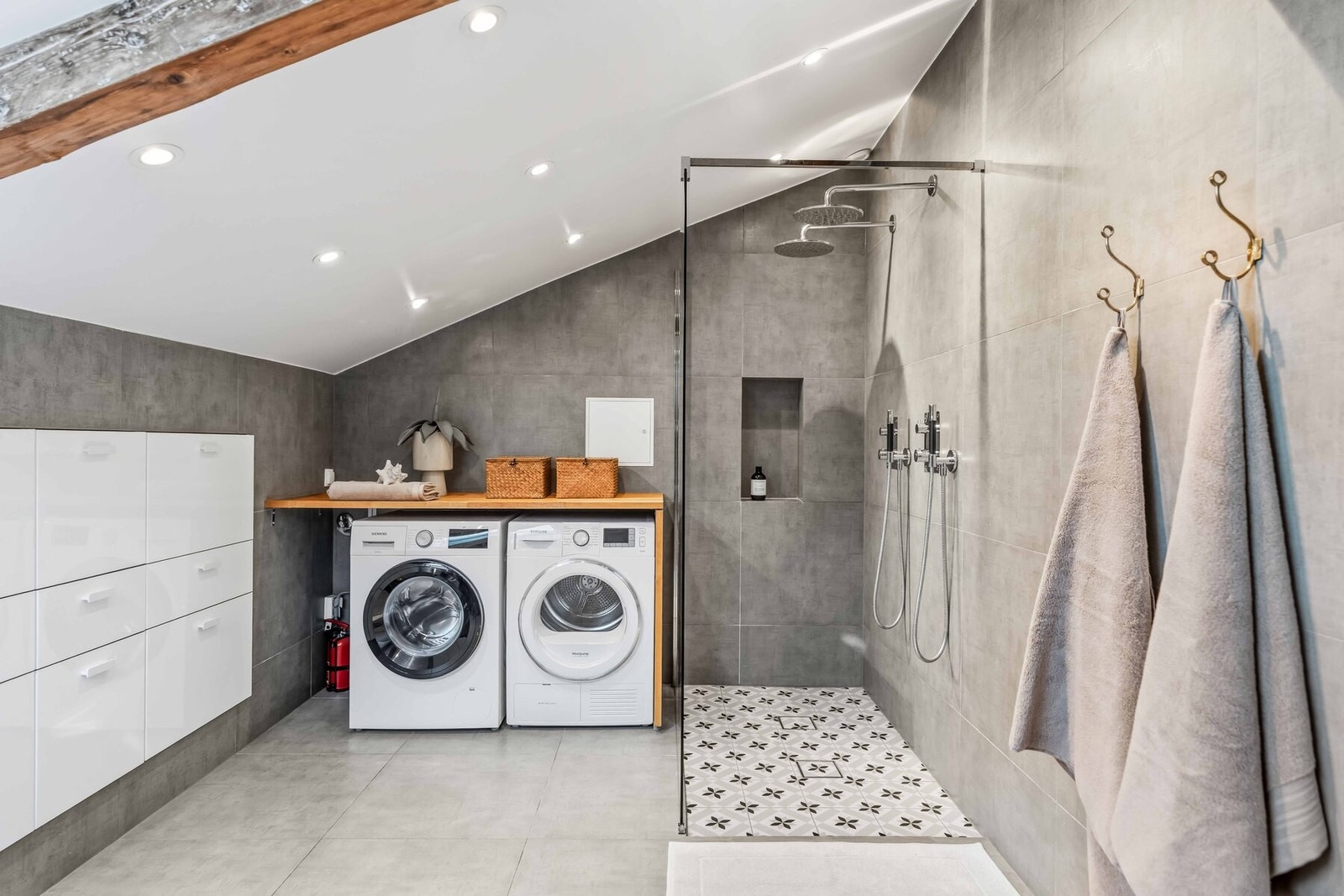 Moderne bad med nedfelt servant, vegghengt toalett og dusjvegg i herdet glass. Gulvvarme og godt lys fra både takvindu og belysning. Galleribilde