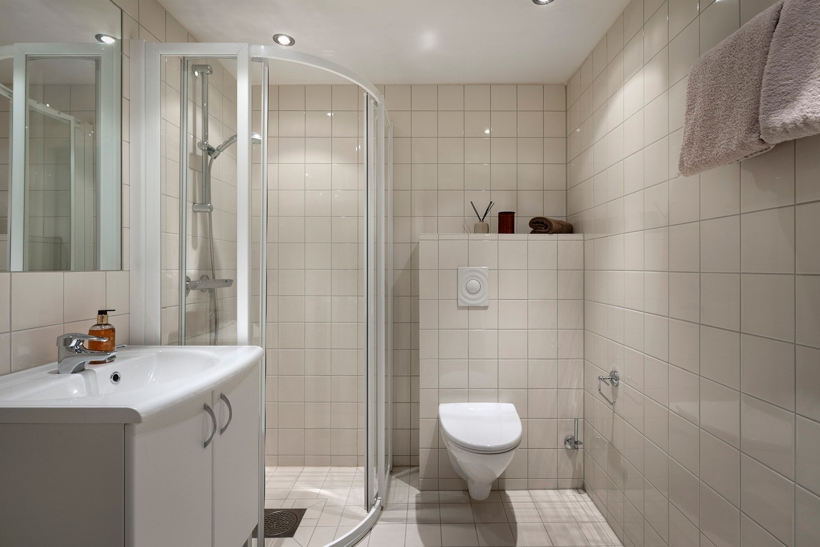 Bad 2 innredet med vegghengt servantinnredning, dusjhjørne med dører og vegghengt toalett. Galleribilde