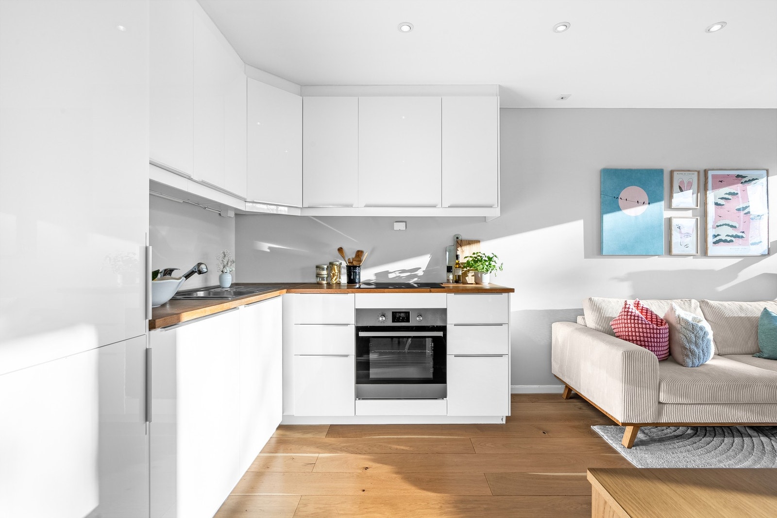 Åpen stue- og kjøkkenløsning gir et sosialt oppholdsrom. Pent og tidløst kjøkken, med heltre benkeplate og hvit kjøkkeninnredning fra IKEA (2014). Galleribilde