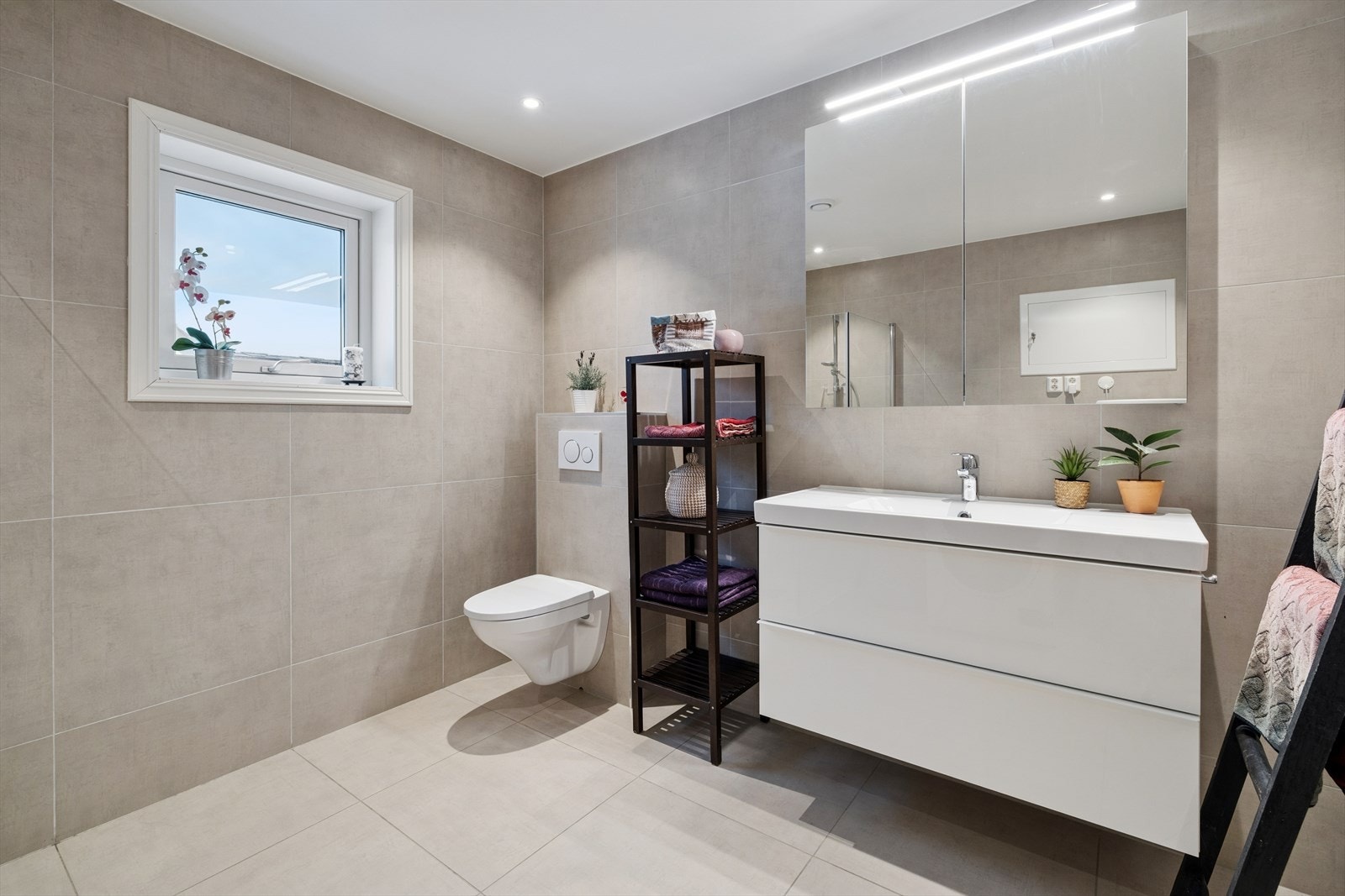 Badet fra 2018 fremstår moderne og tidløst, med fliser på både gulv og vegger som gir et rent og stilfullt uttrykk. Gulvet er utstyrt med elektriske varmekabler som sørger for behagelig varme og ekstra komfort gjennom hele året. Galleribilde