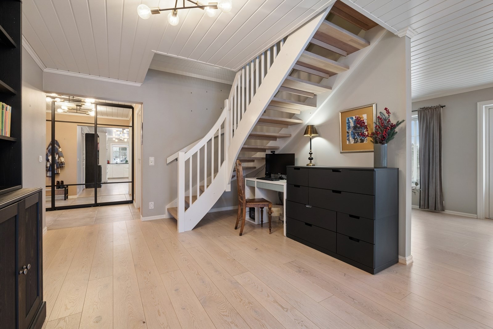 Fra første etasje leder en solid vinkeltrapp i tre opp til boligens andre etasje. Trappen er både funksjonell og estetisk, og binder etasjeplanene sammen på en fin måte. Galleribilde