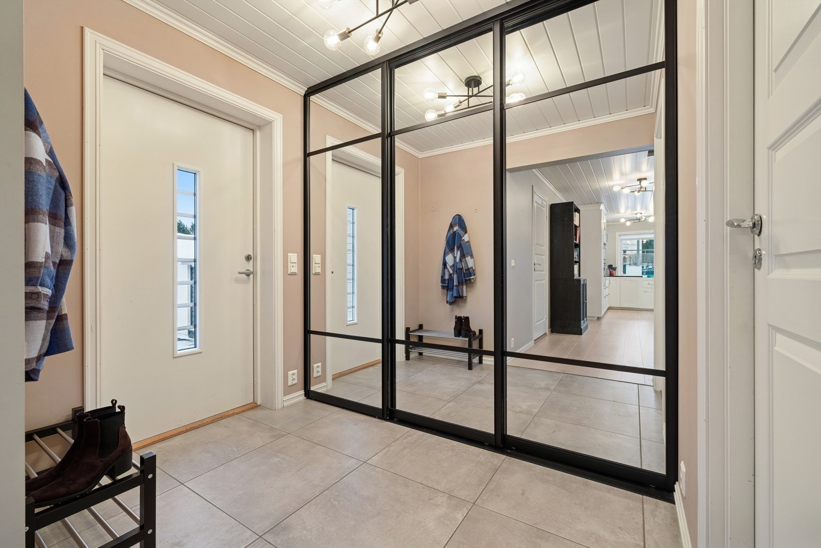 Når du kommer inn i boligen, møter du en lys og romslig entré med skyvedørsgarderobe med speilfronter og flislagt gulv med varmekabler. Fra entréen har du tilgang til en romslig bod som gir gode lagringsmuligheter. Galleribilde