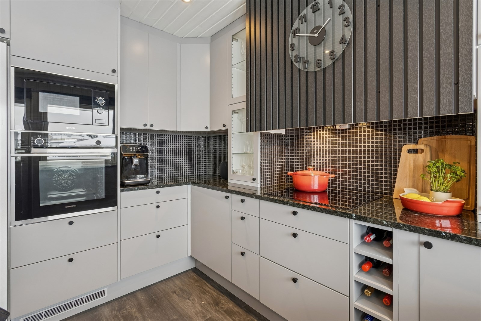 Kokesonen har induksjonstopp, ventilator med avtrekk ut og mosaikkfliser over benken. Galleribilde