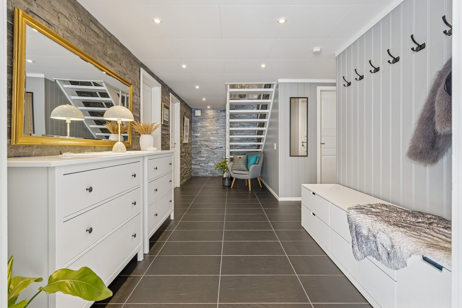 Entréen har elektrisk gulvvarme for økt komfort, og trappen leder opp til hovedetasjen. Galleribilde