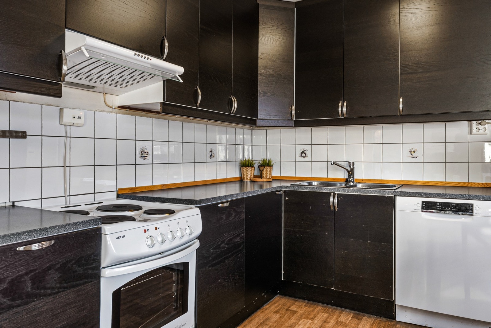 Kjøkkenet har takhøy innredning med mørke fronter i trestruktur Galleribilde