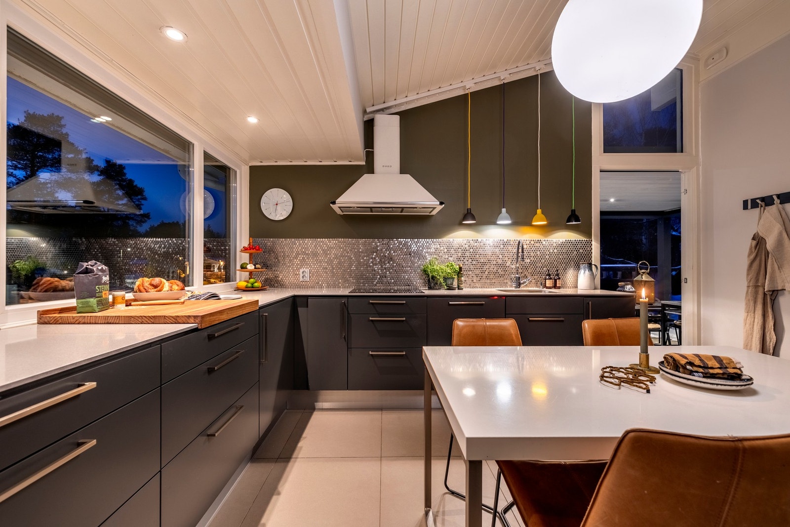 Kjøkkenet er utstyrt med integrerte hvitevarer som induksjonstopp, komfyr, oppvaskmaskin, kjøleskap og fryseskap. Galleribilde