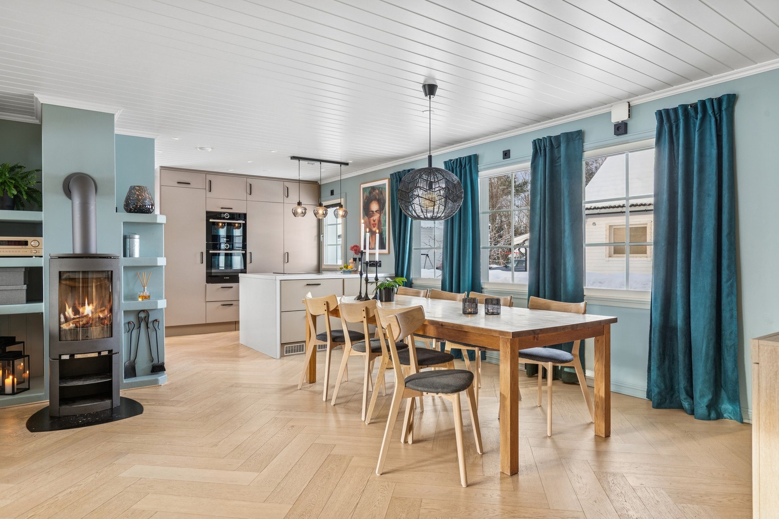 En herlig vedovn gir både varme og stemning på kjølige kvelder, og fiskebensmønstret parkett gir rommet et eksklusivt og tidløst preg. Galleribilde