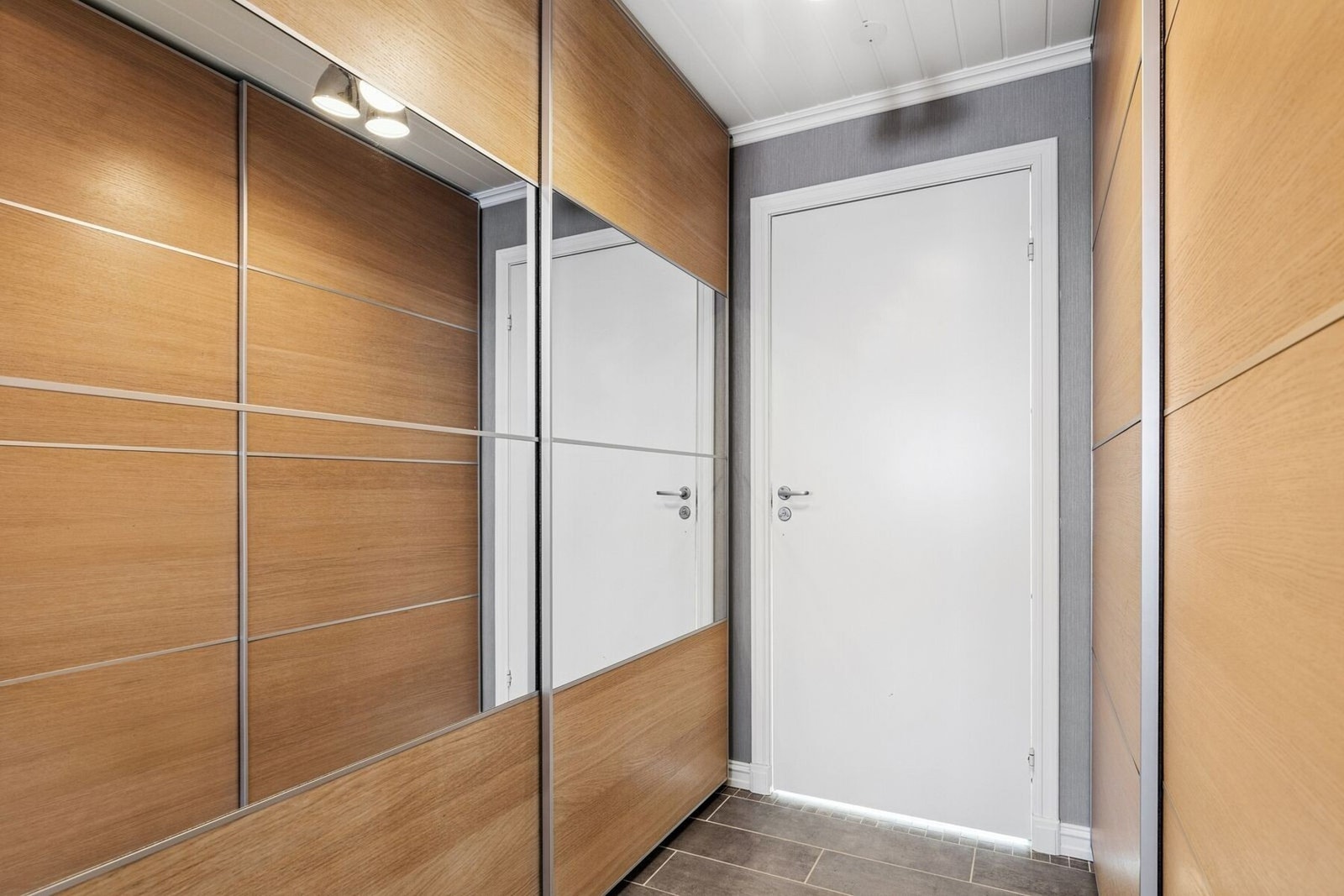 Entrèen er godt utstyrt med skyvedørsgarderobe med speilfroner. Galleribilde